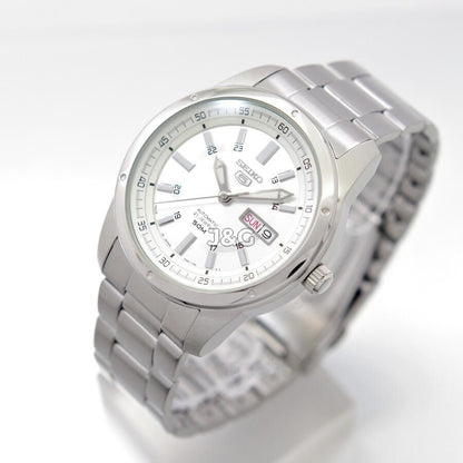 Seiko Automatic movement Black Stainless steel Male SNKN09J1. A brand-new Seiko watch featuring a Black dial and a Stainless steel strap. Angled view. - view 3